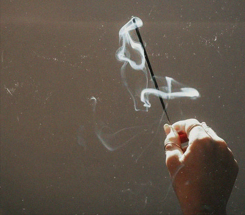 Astrologer and tarot reader Chris Corsini blog post, a fog clearing visualization exercise for any time you feel unclear, hand holding burning incense stick.