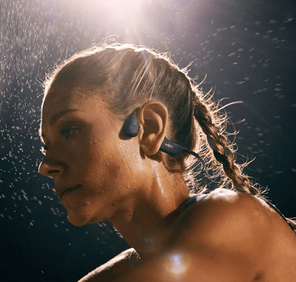 woman running in the rain with black bluetooth headphones on