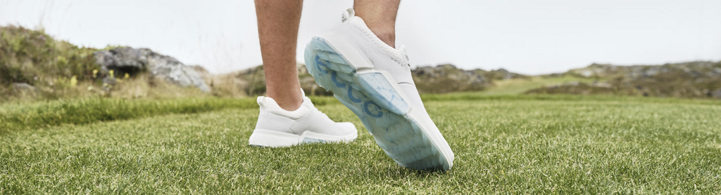 someone wearing footjoy golf shoes on grass