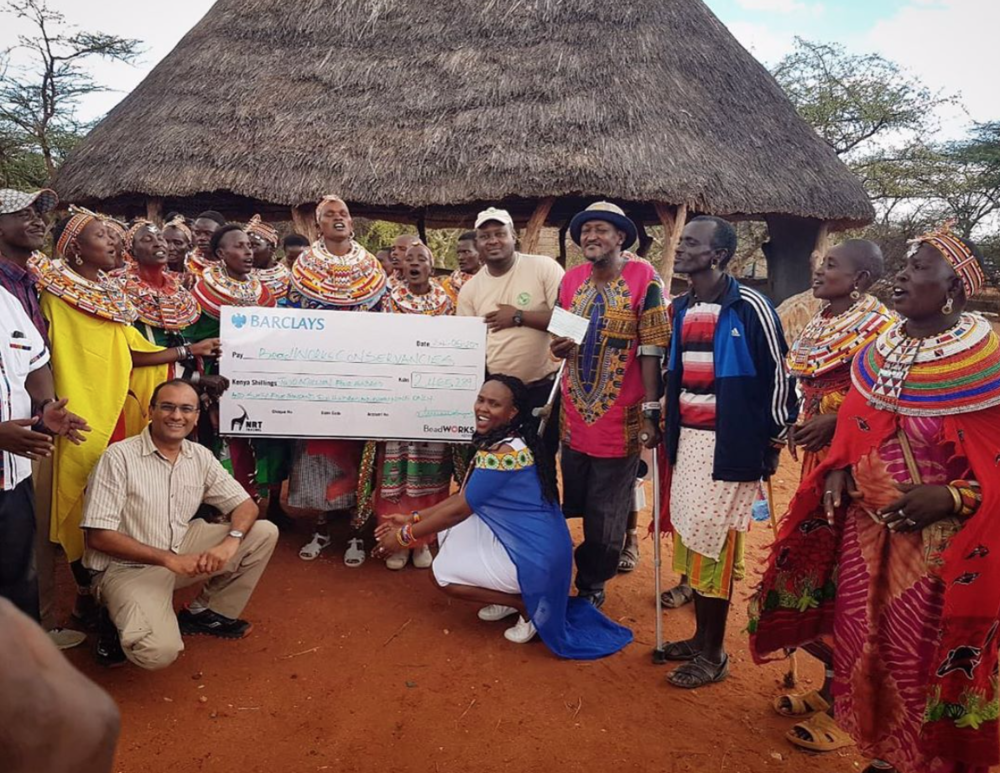 The BeadWORKS artisans of Kalama Conservancy present their conservation  contribution check for 2018 to their chairperson during a ceremony in  late May.