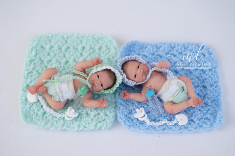 two aidens with bonnets on a little mat