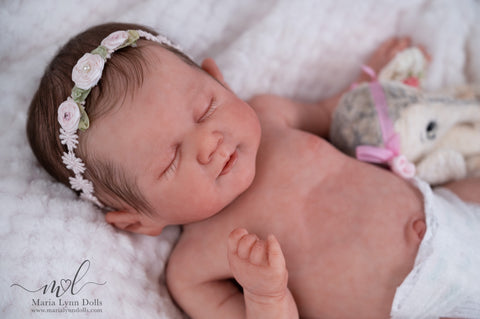 Silicone baby Lily with a floral headband and stuffed animal