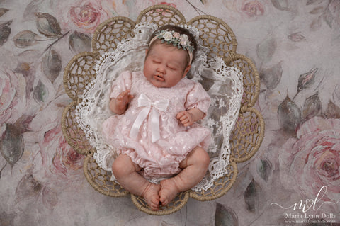 Baby Laurel wearing a sequined pink romper and laying in a basket