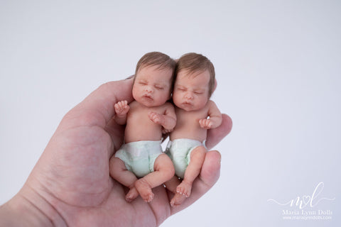 two ivy dolls in the palm of a hand