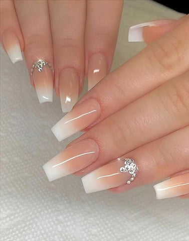Photo of a bejewelled manicure featuring 3D gems, which is one of the top wedding nail art trends of 2023