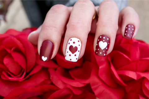 Red and white nails with polka dots on an a heart in the middle of the spotty nails