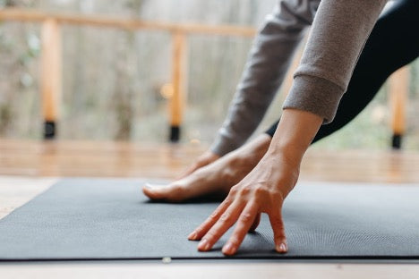 5 Scientific Reasons Why You Should Take Rest Days: A close up of a woman on a yoga mat.