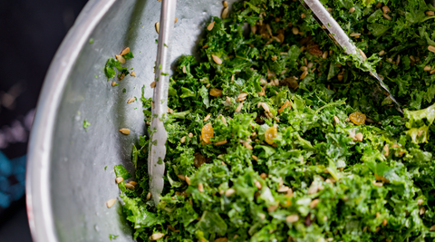 Here's 5 Healthy Recipes for Your Lifestyle: A pair of tongs tosses a kale salad in a metal bowl.