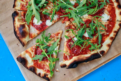 Here's 5 Healthy Recipes for Your Lifestyle: A pizza lays in a wooden cutting board on a blue tabletop.