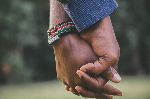 How a Gratitude Journal Can Improve Your Well-being: A man and a woman hold hands with each other.