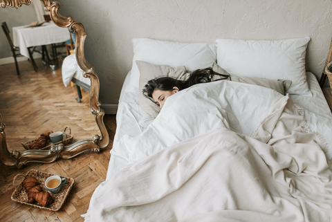 How a Gratitude Journal Can Improve Your Well-being: A woman lays asleep in bed.