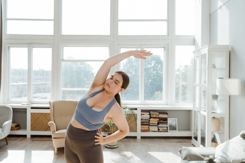 Should You Stretch After Working Out? Yes, and Here's Why: A woman stretches her arm over her head.