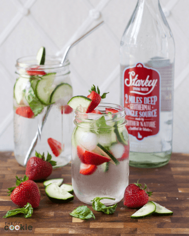 3 Water Infusions to Help You Hydrate: A mason jar with strawberries, basil and cucumbers sits on a wooden tabletop.