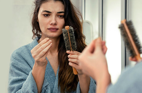 lady is holding her comb and her hairs in one hand