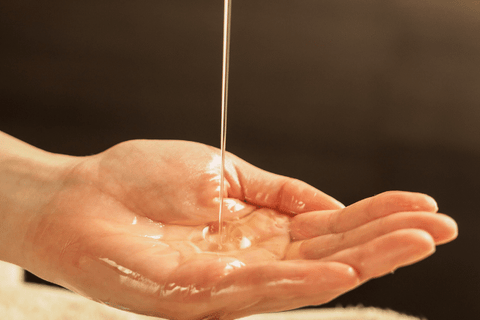 Oil being poured on the cupped hands