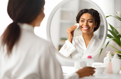 Lady is removing her dead skin from cheeks after she applied natural face tonic