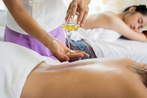 masseuse is taking natural body oil in hand