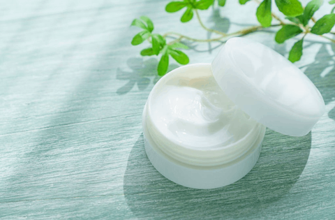 face cream with its lid is placed on the side of container