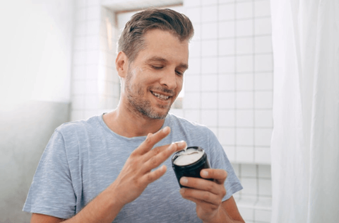 men is picking cream from the men face cream 