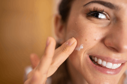Girl is applying anti aging cream on her face