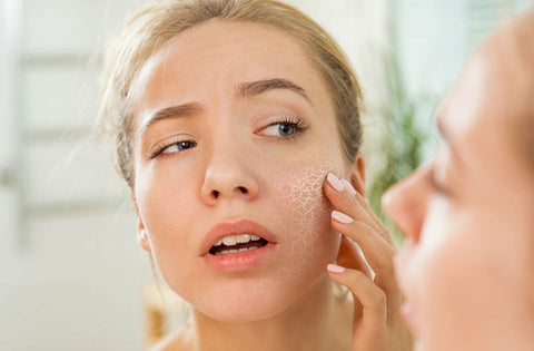 lady is watching herself in the mirror after seeing her dry skin on cheeks