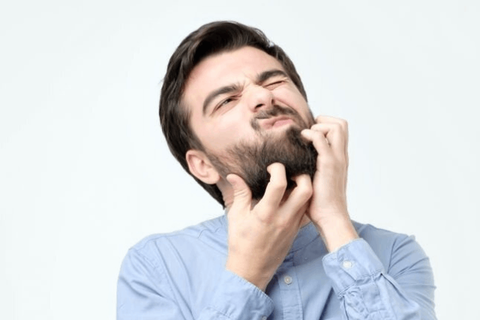 men is irritated by scratching his beard due to dry and itchiness on it 