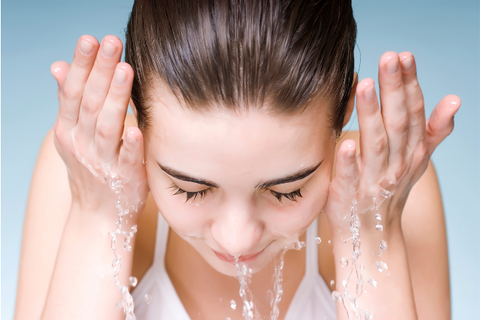 girl is washing her face by water 