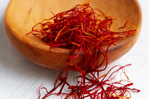 saffron threads are spread over wood spoon 
