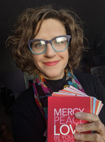 Amanda Bridle holding a stack of Bible verse postcards she designed