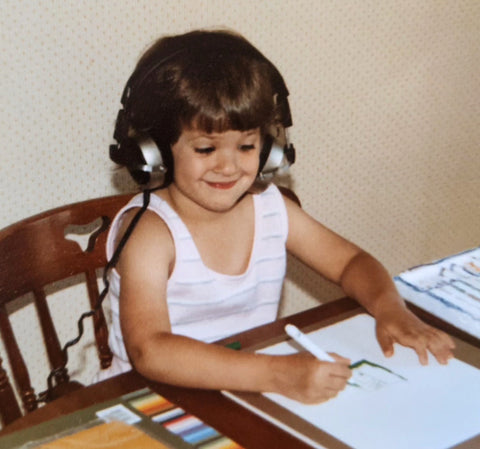 child wearing headphones drawing with markers