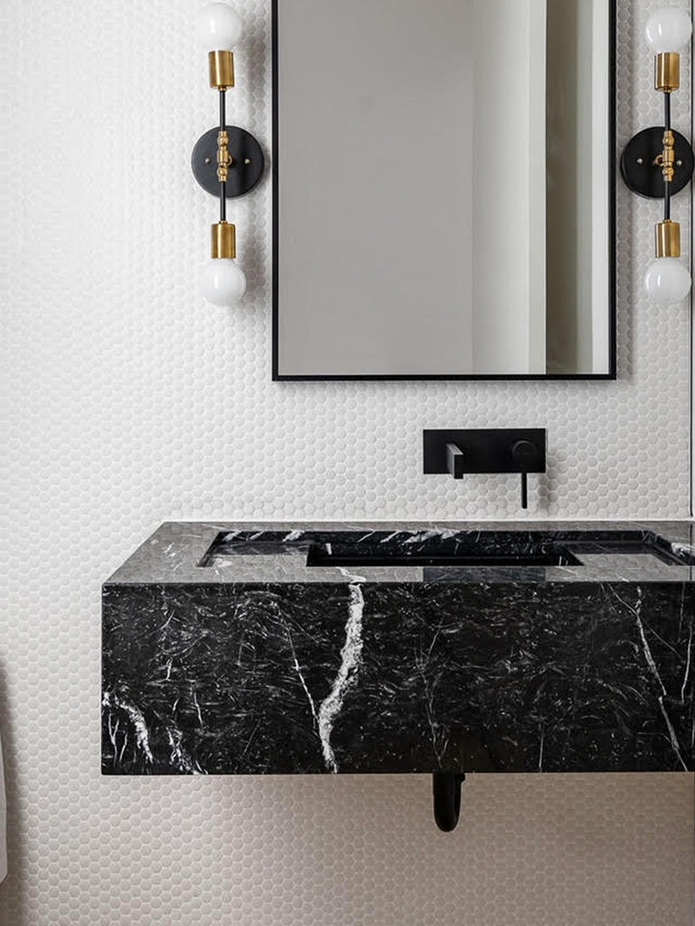 black marble countertop in a white penny tile bathroom