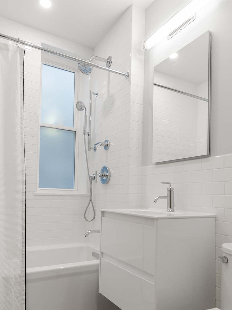frameless bathroom mirror over white bathroom vanity