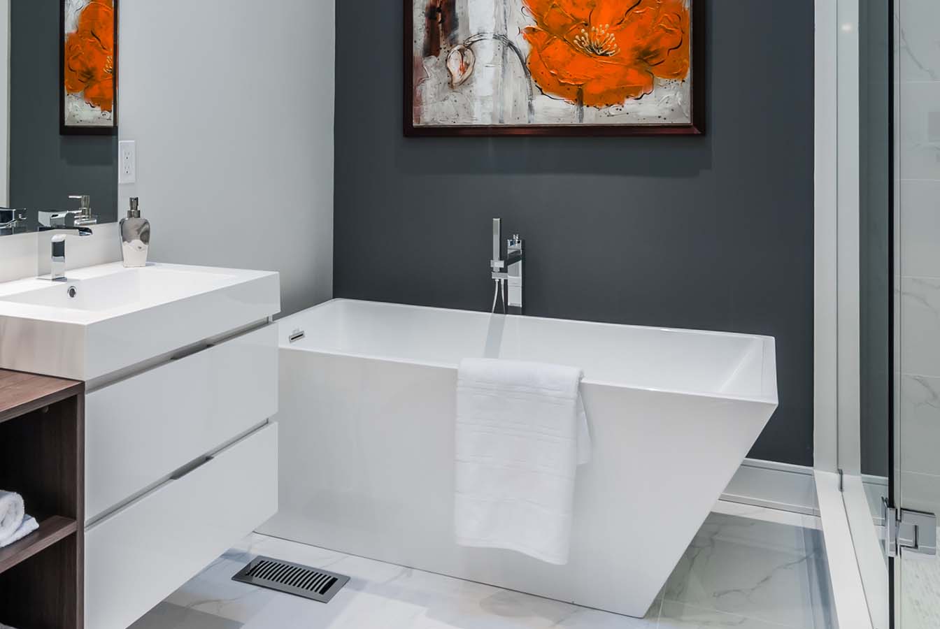 White acrylic square bathtub with grey wall and orange abstract painting