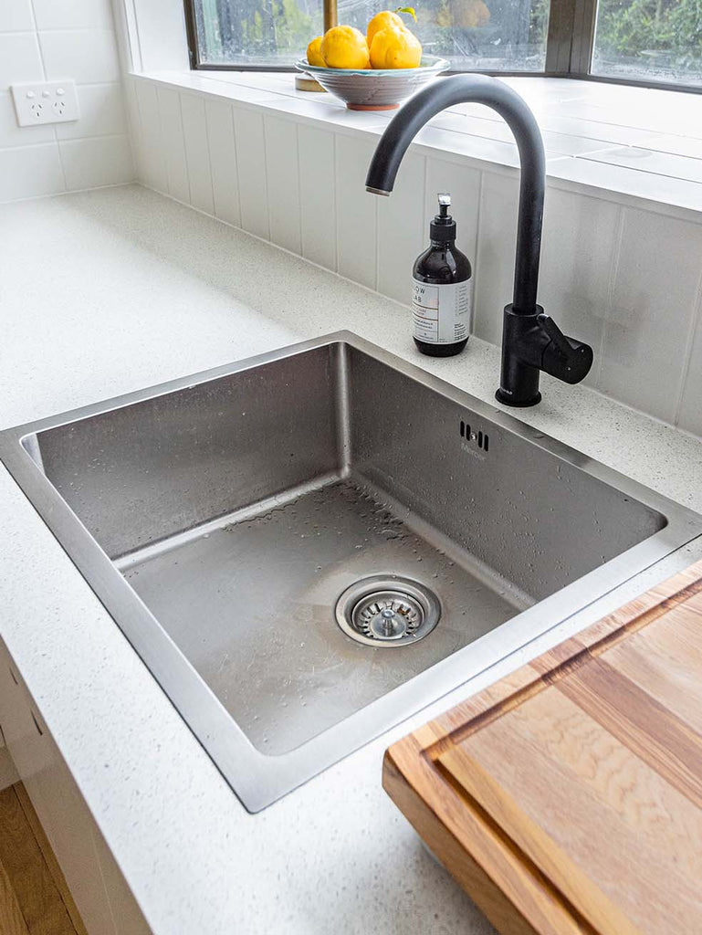 drop in sink with matte black faucet and lemons on the window 