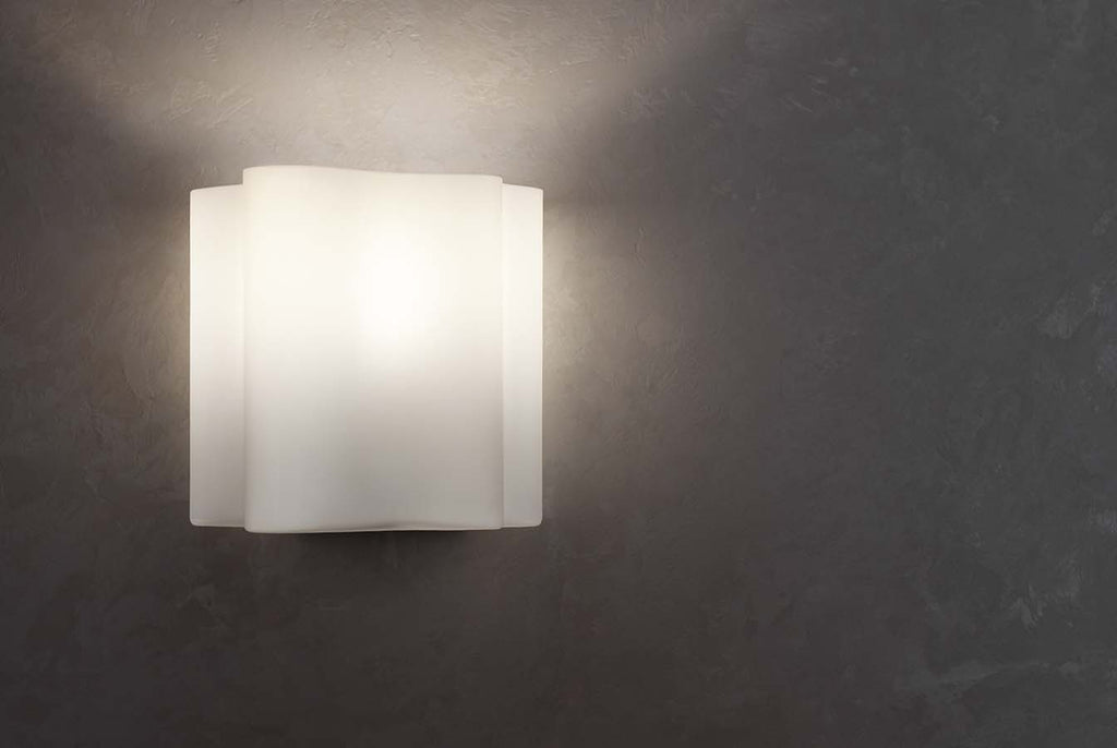 light sconce lit up with dark wall background