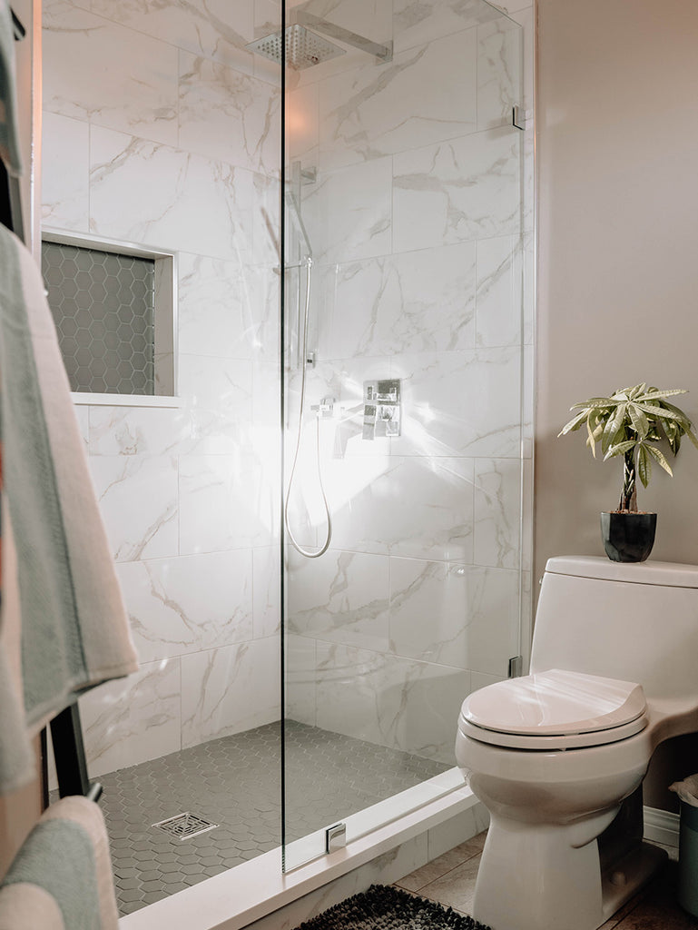 bathroom shower with marble tile walls 