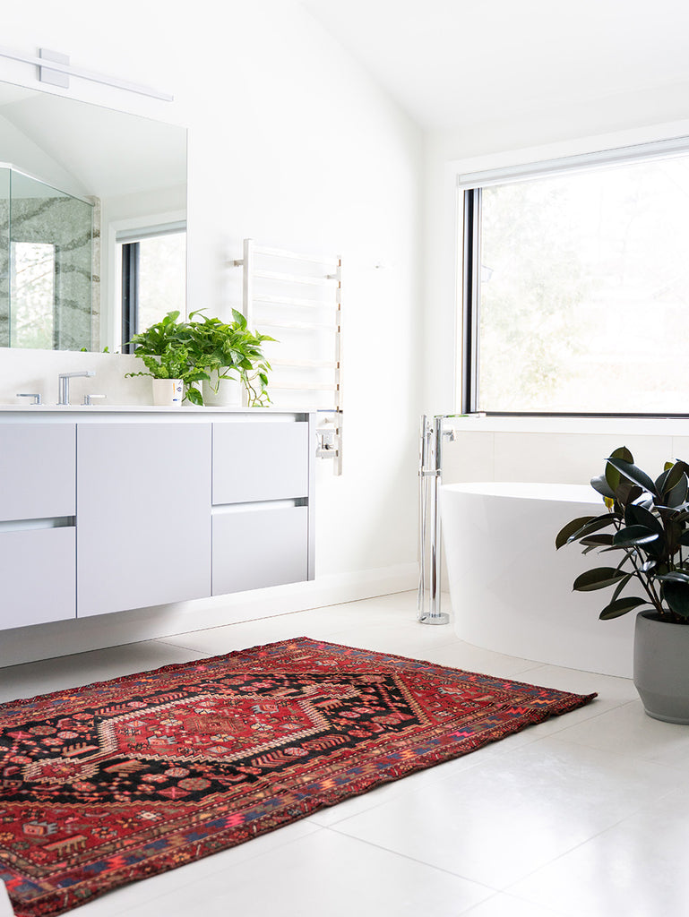 white bathroom in the morning with red bathroom rug