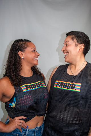 LGBTQIA+ models joyfully laughing while wearing our pride vests, capturing the essence of celebration during Pride Month.