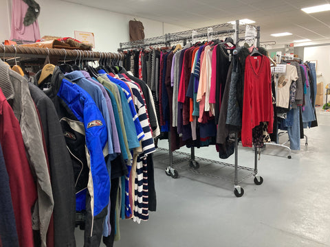 General view of clothes hanging on rails in second hand shop UK