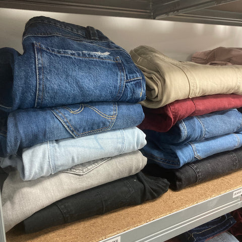 second hand jeans folded on a shelf