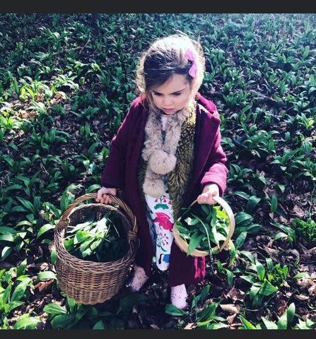 Child carrying baskets of plants