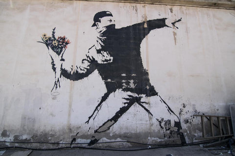 Banksy Love Is In The Air. Photo of banksy love is in the air mural in west bank palestine. Stencilled man launching bouquet of flowers instead of brick in protest