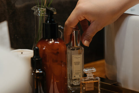 a lady picking up a perfume bottle