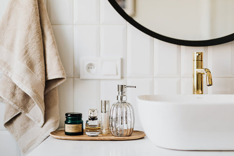 a white bathroom with perfumes on the counter