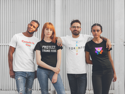 a group of four friends pose with Queer Geekery t-shirts on. On the left is a white tee that says "Canada is gay" in retro lettering; to the right of that, a black tshirt with "protect trans kids" in white text; to the right of that a white tshirt with "Toronto Proud" in colourful lettering; then a black shirt with the pink progress pride maple design. 