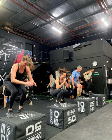 A group fitness class using an xpeed plyo box