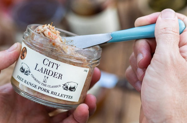 open jar of city larder rillettes with blue handled knife in jar