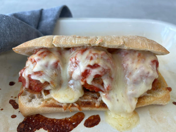 crusty bread roll filled with meatballs and melted cheese