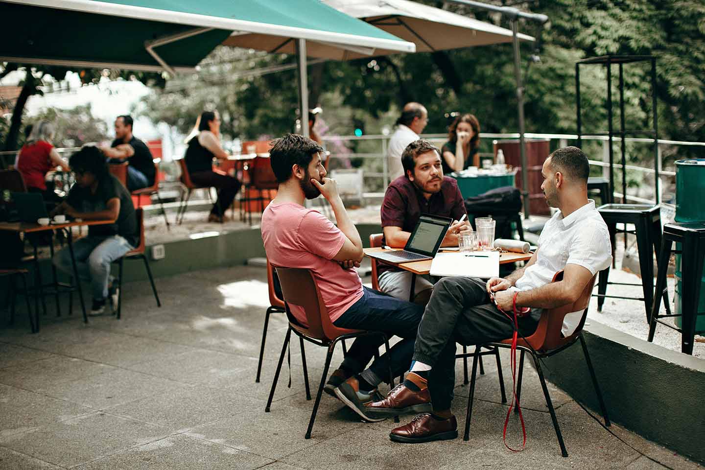 Three men sitting at a cafe