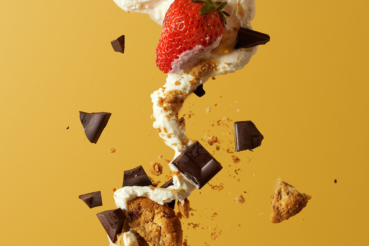 strawberry fruit, cookies, and chocolates against a yellow background